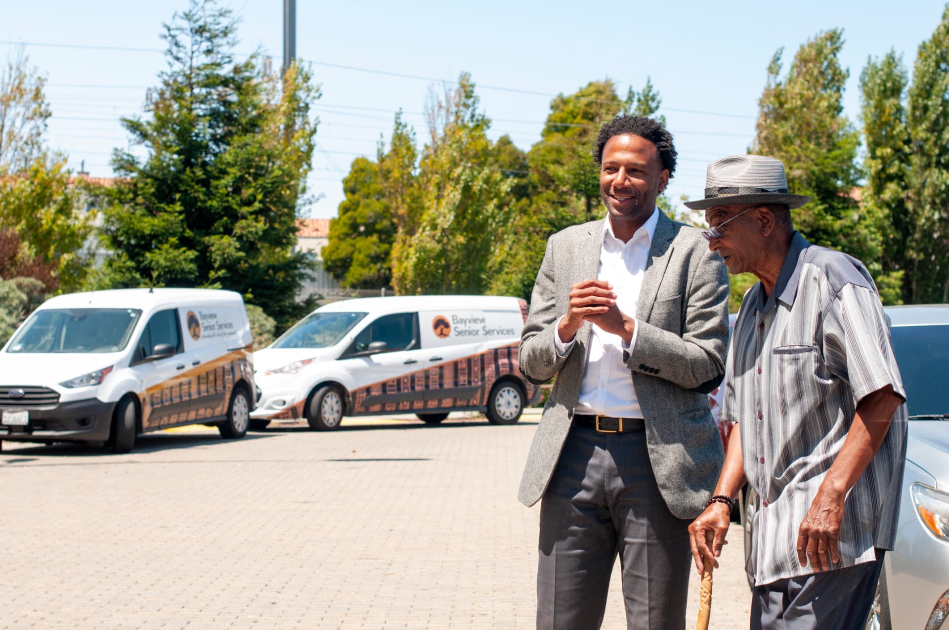 Theo Ellington talking with a senior outside Bayview Senior Services
